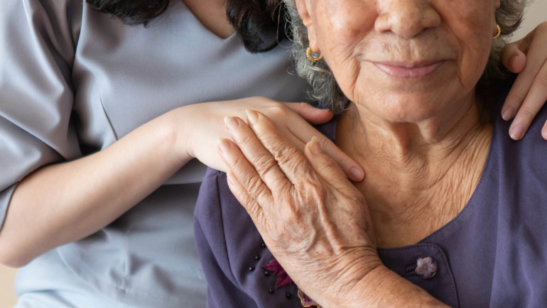 A caregiver aiding an older person.